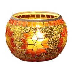 a candle that is sitting on top of a white surface with an orange and yellow mosaic design