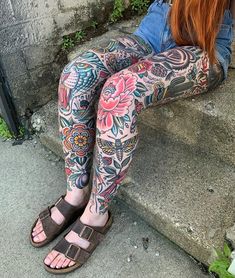 a woman with red hair and tattoos on her legs sitting on the steps wearing sandals