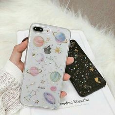 a person holding an iphone case with stars and planets on it in front of a white fur