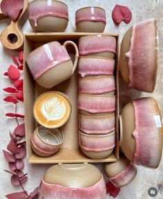 there are many different types of pottery in the box and one is pink with white on it