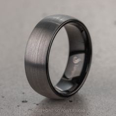 a wedding ring is shown on the floor with grey wood inlay and black ceramic