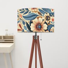 a wooden tripod floor lamp with a floral fabric shade on it's base