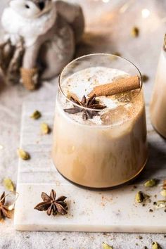 two glasses filled with coffee and cinnamon on top of a table