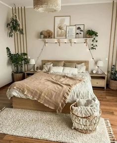 a bedroom with white walls and wooden flooring is decorated in neutral tones, including beige bedding