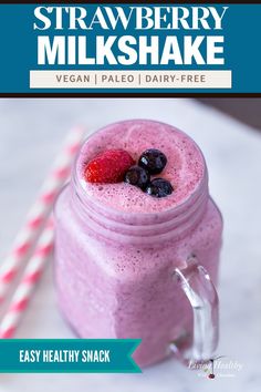 a smoothie in a mason jar with strawberries and blueberries on the top