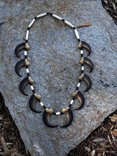 a necklace made out of horns on top of a rock