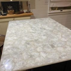 a white counter top in a kitchen next to a window