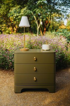 a green dresser with a lamp on top