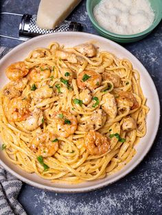 a plate of pasta with shrimp and parmesan cheese