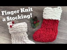 two knitted christmas stockings sitting on top of a wooden floor next to a pine cone