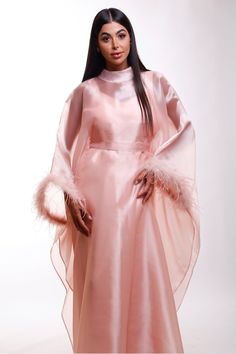 Wrap yourself in luxurious splendor with this stunning shimmer pink Organza maxi caftan dress, designed with ethereal butterfly sleeves with elegant feathers and a refined high neckline. A perfect choice for black-tie affairs, lavish resorts, wedding guests, or any occasion where timeless glamour is essential. Envision yourself gliding through a grand ballroom or strolling along an oceanfront terrace, the dress catching the light in the most alluring way. This caftan is your invitation to feel a Silk Kaftan With Cape Sleeves For Party, Pink Cape Sleeves Maxi Dress For Party, Pink Cape Dress For Wedding, Elegant Pink Gown With Cape Sleeves, Pink Party Maxi Dress With Cape Sleeves, Pink Maxi Dress With Cape Sleeves For Party, Elegant Evening Abaya With Cape Sleeves, Elegant Abaya With Cape Sleeves For Evening, Pink Cape Sleeves Evening Gown