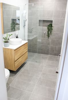 a bathroom with a sink, toilet and shower stall is seen in this image from the doorway