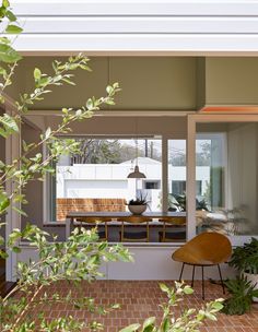 an open patio with chairs and plants in the foreground