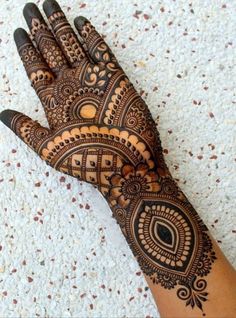 a henna on someone's hand that is showing the intricate designs and colors