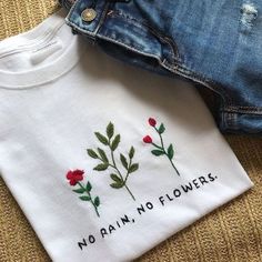 two t - shirts that say no rain, no flowers and one with roses on it