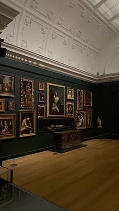 an empty room with paintings on the wall and wooden flooring in front of it