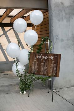 a sign and some white balloons in front of a building