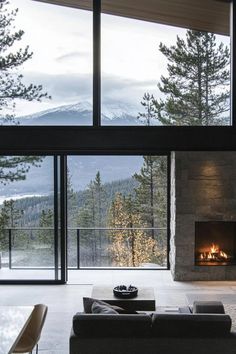 a living room filled with furniture and a fire place in front of a large window