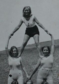 three women are standing in the grass with their hands together