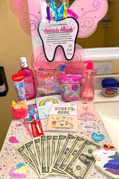 an assortment of toothbrushes, soaps, and money on a counter top