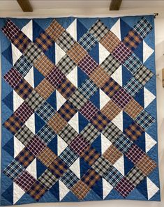 a blue and white quilt hanging on the wall