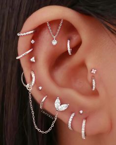 a woman wearing multiple ear piercings with stars and moon designs