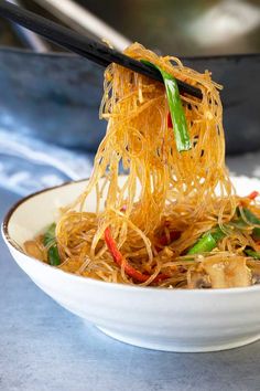 a bowl of noodles with chopsticks in it