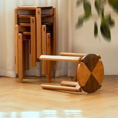 a stack of wooden chairs sitting next to each other on top of a hard wood floor