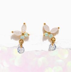 Capture the essence of springtime with our Wings of Wonder Dangle Earrings. A fresh take on our best-selling Mari butterfly design, these earrings feature a stunning combination of clear and light green stones that will leave you in awe. But that's not all - each butterfly's wing is adorned with an adorable dewdrop-like stone that dangles with every movement, adding a touch of playfulness and charm to the design. Let your sense of style take flight! Delicate Green Jewelry For Spring, Delicate Green Flower Earrings For Pierced Ears, Elegant Spring Jewelry With Butterfly Charm, Elegant Spring Butterfly Jewelry, Elegant Light Green Drop Earrings, White Drop Earrings With Butterfly Charm, Silver Butterfly Charm Drop Earrings, Butterfly Wing Earrings Ohmybutterfly, Butterfly Charm Wing-shaped Earrings For Gift