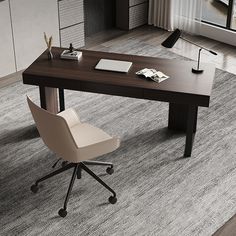 an office desk with a chair and laptop on it