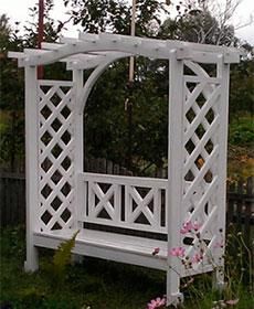 a white bench sitting in the middle of a garden