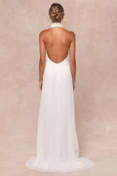 the back of a woman wearing a white wedding dress with an open back and low cut neckline