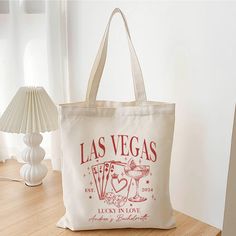 a las vegas bag sitting on top of a wooden table next to a white lamp