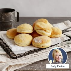 a pile of doughnuts sitting on top of a table next to a cup