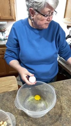 an older woman in the kitchen preparing food for her family's meal, including eggs and potatoes