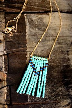 This stylish beaded necklace is the perfect statement piece! It is made of turquoise, blue, and brown beads hanging from a gold chain. It is 21 inches long. The beaded pieces are 2 inches long. Turquoise Beaded Dangle Necklaces, Turquoise Beaded Chain Necklace With Dangle, Turquoise Beaded Dangle Necklaces With Tiny Beads, Turquoise Dangle Beaded Necklaces With Tiny Beads, Blue Dangle Beaded Necklace With Tiny Beads, Bohemian Turquoise Beaded Necklace With Gold Beads, Bead Bar Necklace, Beaded Things, Arrowhead Necklace