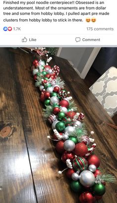 a long line of christmas ornaments sitting on top of a wooden table in front of a tweet