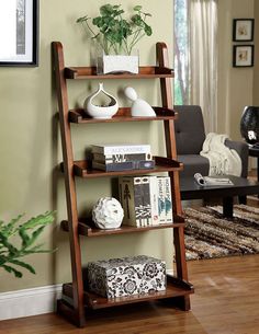 a wooden shelf with books and vases on it in the corner of a living room