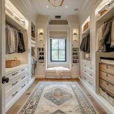 a walk - in closet with an area rug on the floor and shelves full of clothes