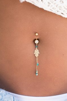 the belly button is adorned with gold and turquoise beads