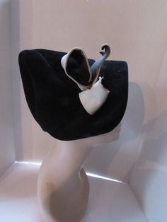 "SALE! 10% OFF! A fanciful vintage hat designed by mid-century milliner Roberta Bernays. In black velour, it confidently assumes a cone shape. On the right side is a folded gray tone vinyl stiff bow. tucked inside the bow are surprising metal coils. The cone shape is achieved by gores from the top of the peak.  Size: 8\" tall at back; 2 1/4\" brim at front; 21\" inner band circumference Condition: very good vintage--velour is without stains or holes. Note--there are two pin head size dots on the Fall Hat, Pin Head, Black Velvet Bow, Cocktail Dress Vintage, Fall Hats, Antique Clothing, Victorian Women, Vintage Hat, Vintage Cocktail