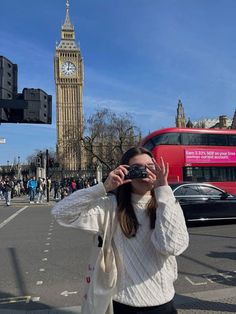 a woman taking a photo in front of the big ben clock tower