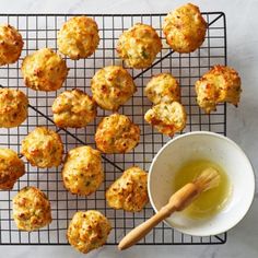 a wire rack with muffins and a bowl of honey