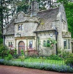 an old stone house surrounded by greenery and trees