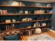 a living room filled with furniture and bookshelves on top of wooden shelving