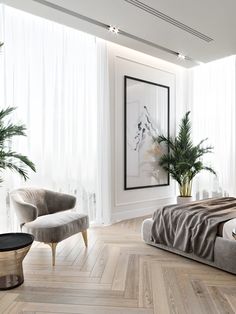 a bedroom with white walls and wood flooring is pictured in this image, there are two chairs on either side of the bed