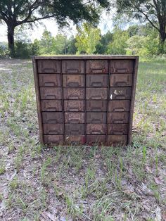 an old wooden cabinet sitting in the middle of a field