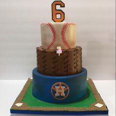 a three tiered cake decorated with baseballs and numbers