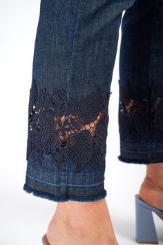 a woman's legs wearing high heels and jeans with lace on the bottom part