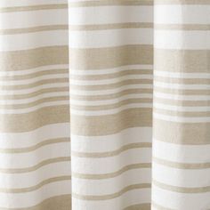 a close up view of a curtain with white and beige stripes